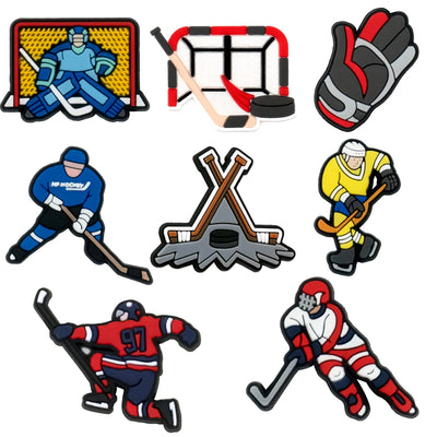 Collection of hockey-themed shoe charms including players, goalie, gloves, and equipment on a white background.