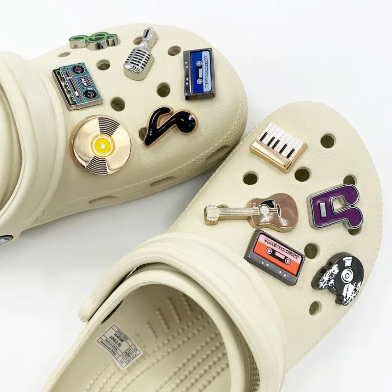 Beige clogs with decorative pins on a white background