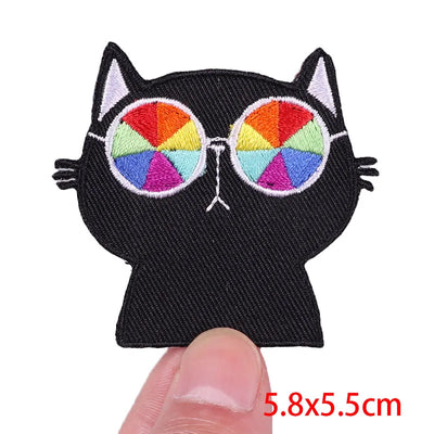 Black cat-shaped patch with colorful sunglasses on a white background