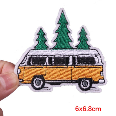 Embroidered patch of a camper van with trees on a white background