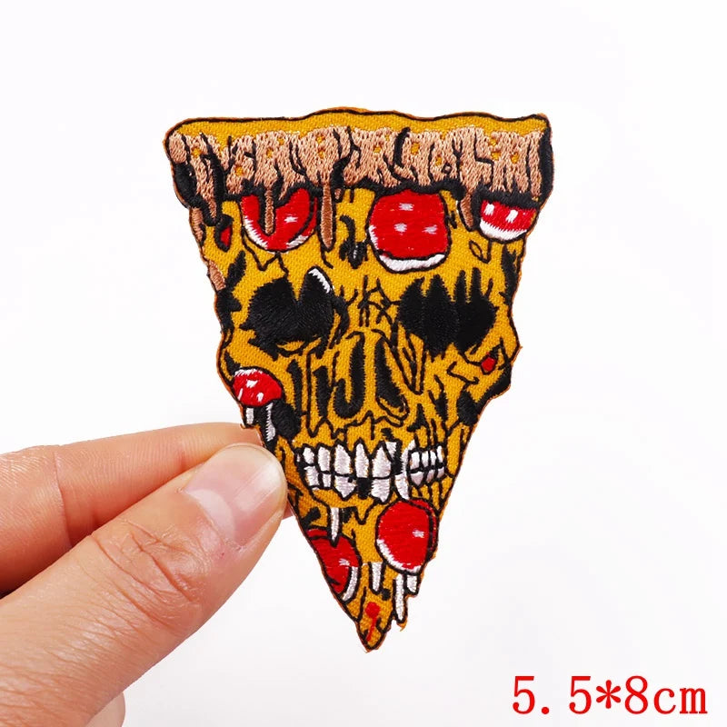 Skull-shaped pizza slice patch held by a hand with a white background