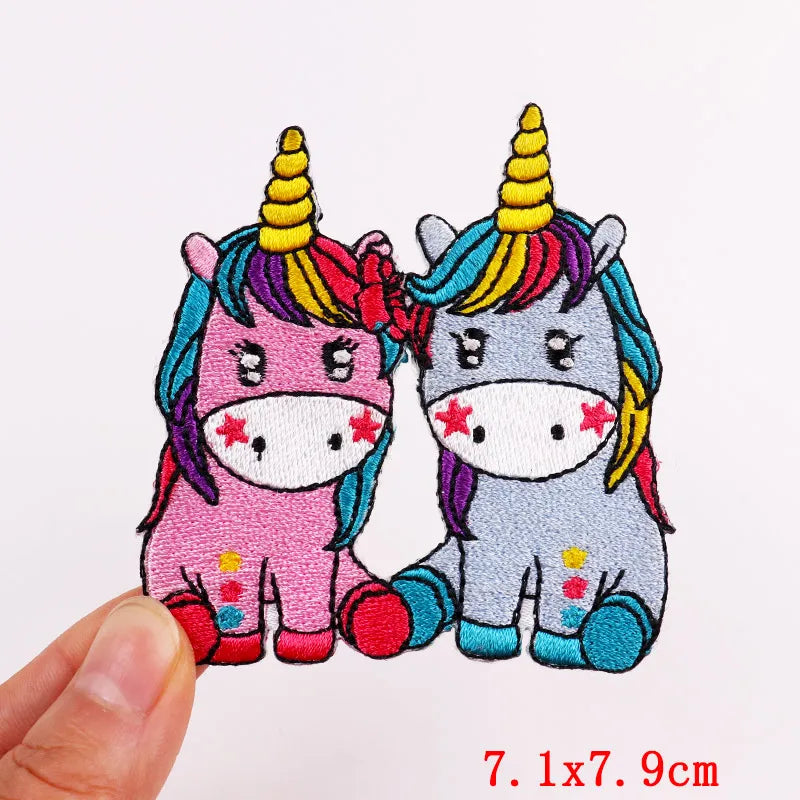 Two colorful unicorn patches with rainbow hair and polka dot patterns on a white background.