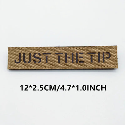 Brown woven label with 'JUST THE TIP' text on a white background
