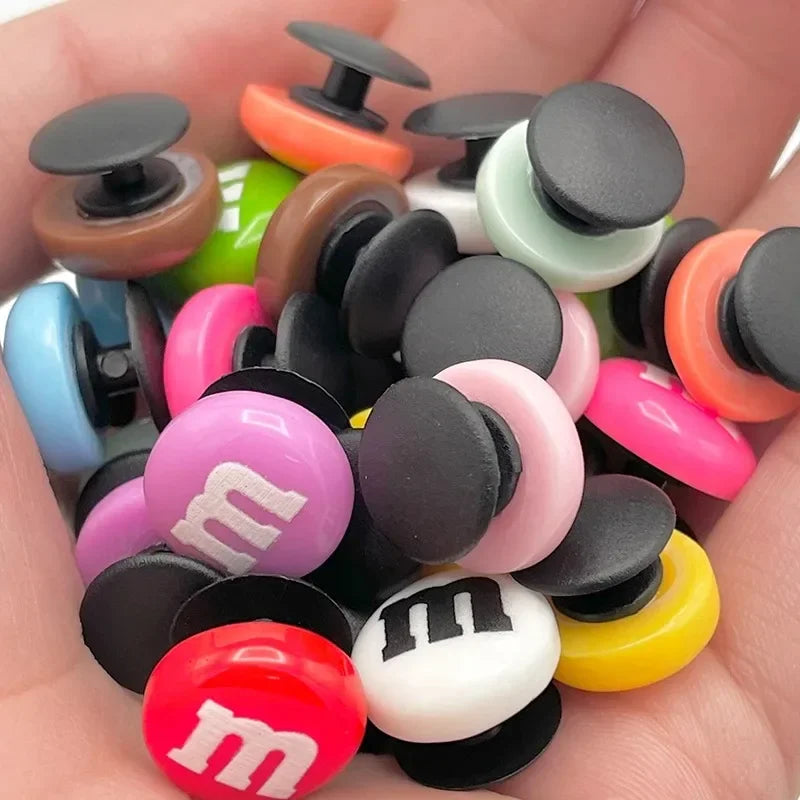 Colorful M&M-style buttons held in a hand