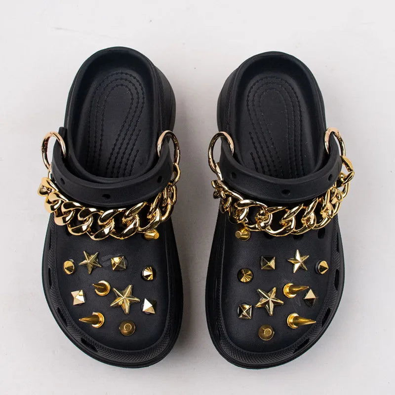 Black clogs with gold Rivet Shoe Charms and chains on a white background