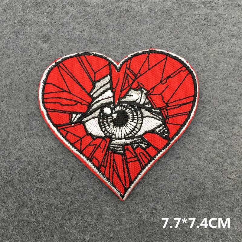 Heart-shaped patch with eye design on a gray background