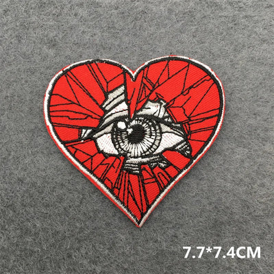 Heart-shaped patch with eye design on a gray background