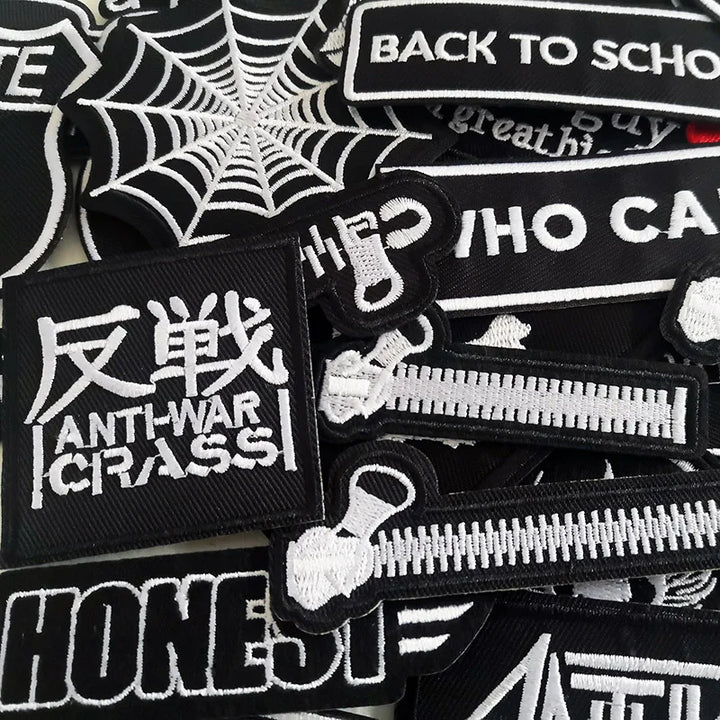 Collection of black and white patches with various designs and text.