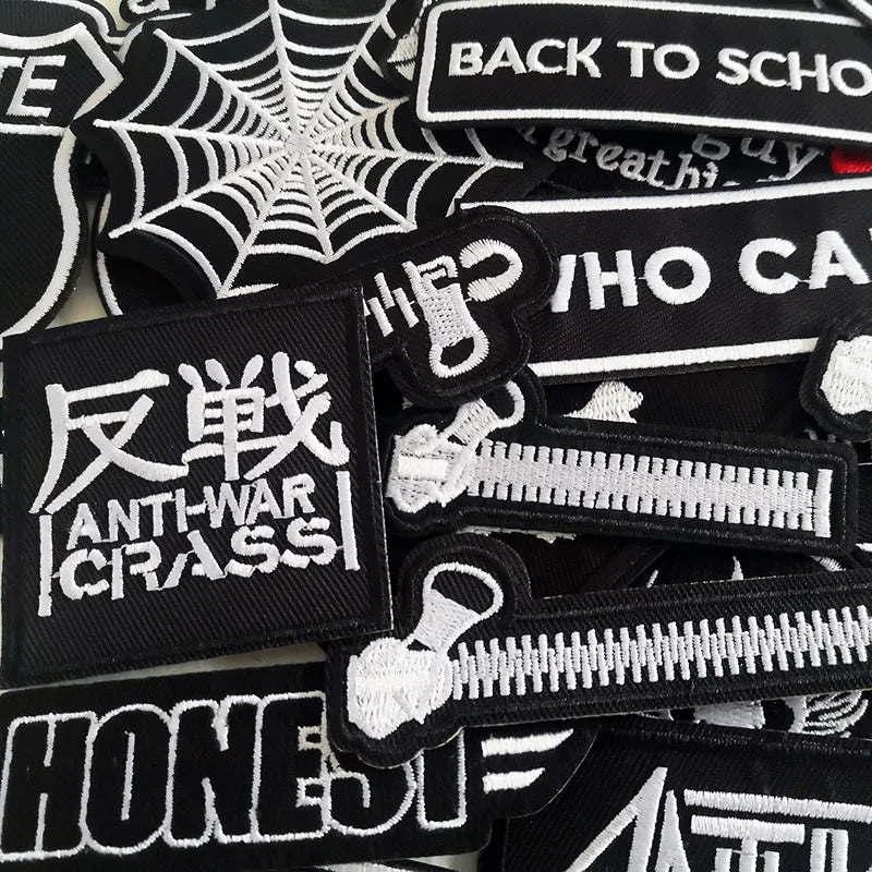 Collection of black and white patches with various designs and text.
