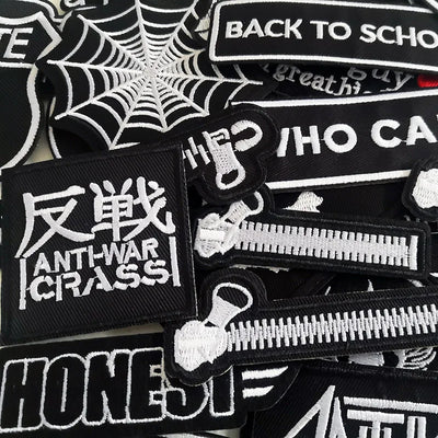 Collection of black and white patches with various designs and text.