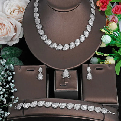 bridal set of necklace bracelet ring and earrings set on a brown stand with flowers in the background
