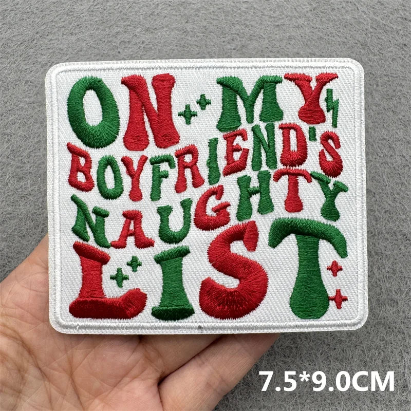 Embroidered patch with colorful text held by a hand on a gray background