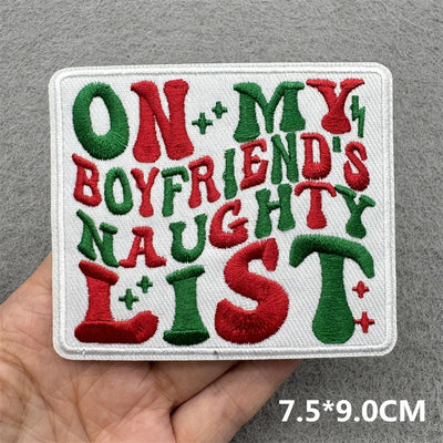 Embroidered patch with colorful text held by a hand on a gray background