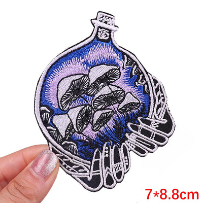 Embroidered patch with blue and purple design held by a hand on a white background