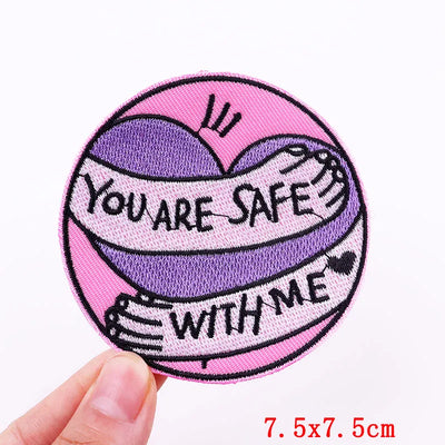 Circular patch with 'You are safe with me' text held by a hand on a white background