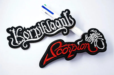 Two embroidered patches with 'Korpihlanti' and 'Scorpion' designs on a white background.