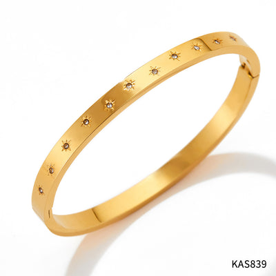 Gold bracelet with small diamonds on a white background