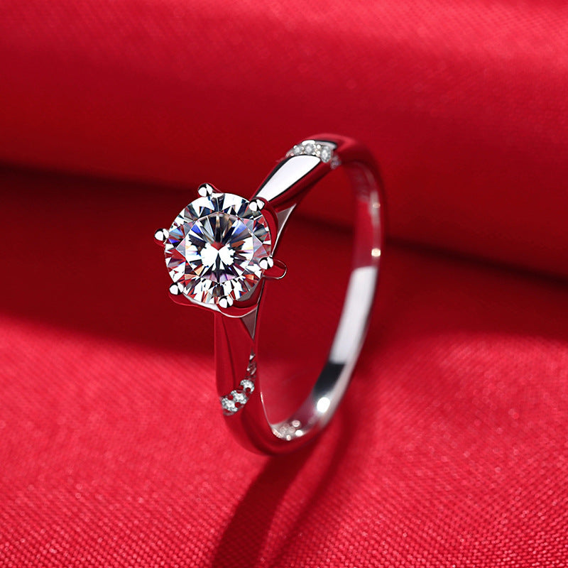 Silver ring with a diamond on a red fabric background