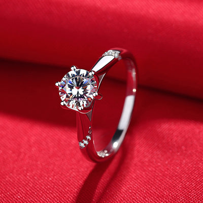 Silver ring with a diamond on a red fabric background