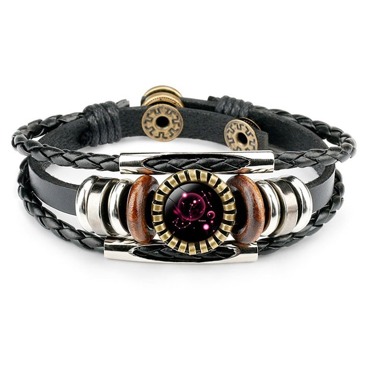 A stylish black leather bracelet featuring braided strands, decorative silver and wood beads, and a central purple gem with a circular gear-like frame.