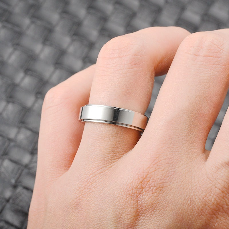 Silver ring on a person's finger with a blurred textured background