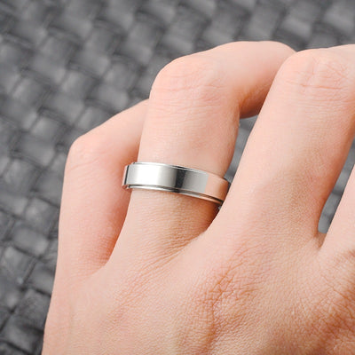 Silver ring on a person's finger with a blurred textured background