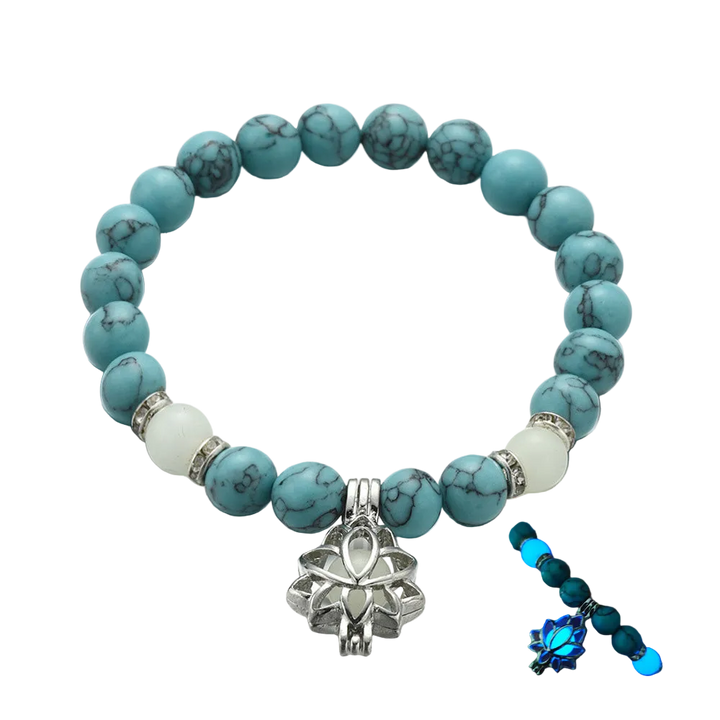 Turquoise beaded bracelet with a silver lotus charm on a white background