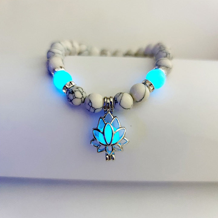 Bracelet with glowing blue lotus charm on a white background
