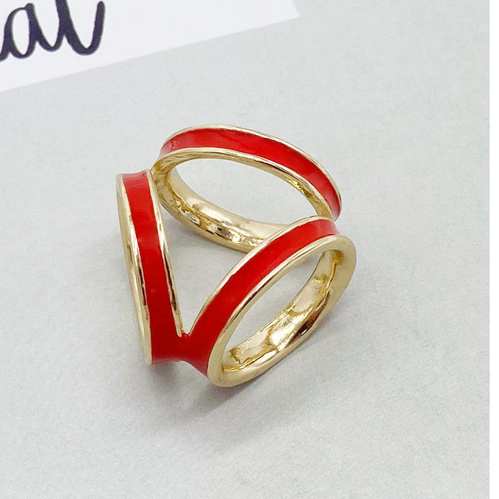 Gold and red ring on a light gray background