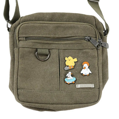 Green shoulder bag with cartoon character pins on a white background