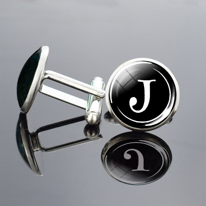 Cufflinks with a black round design featuring the letter &