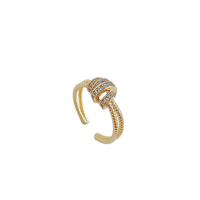 Gold ring with intricate design on a white background