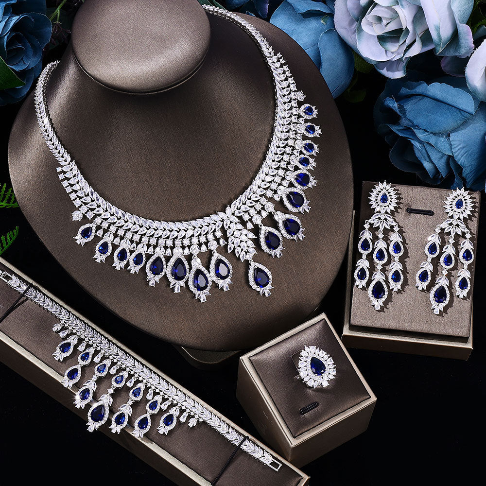 blue stone Jewelry set with necklace, earrings, and ring on a dark surface with blue flowers.
