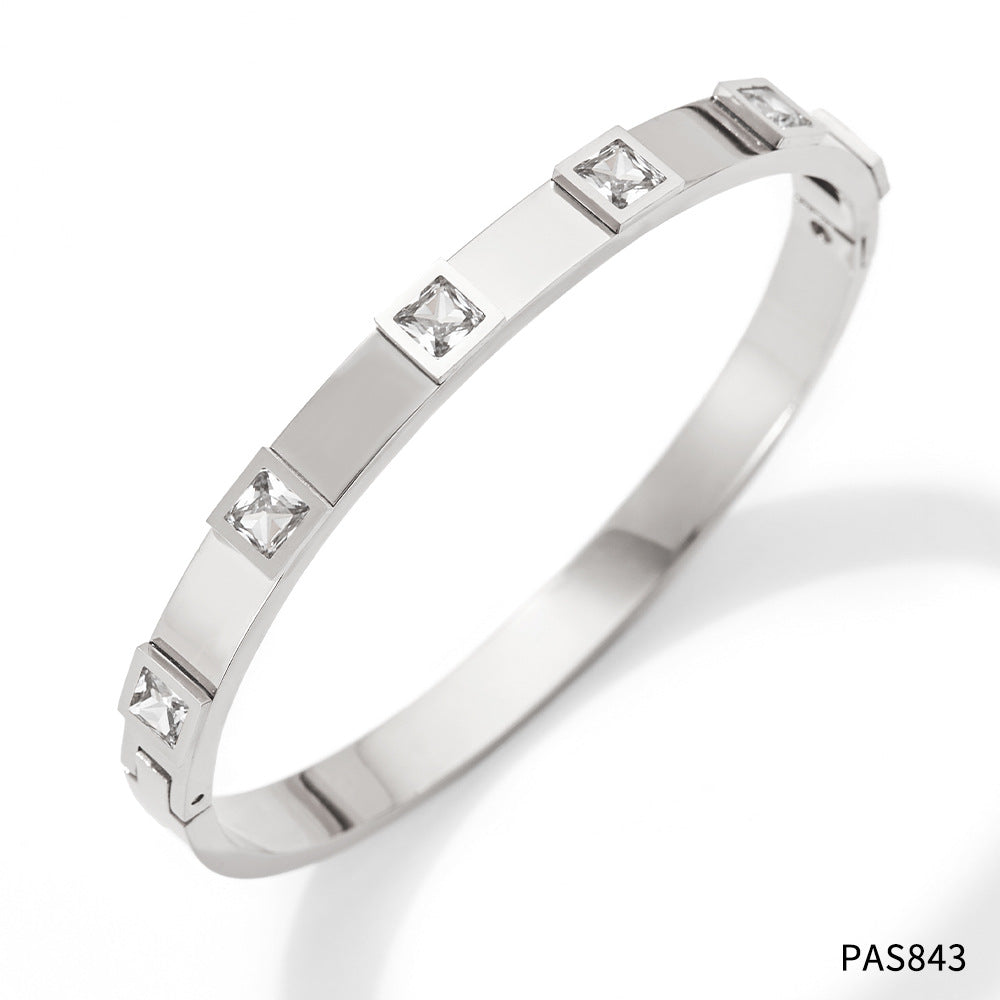 Silver bracelet with embedded diamonds on a white background