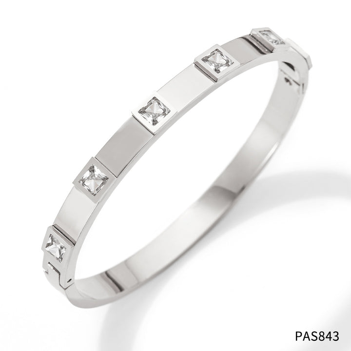 Silver bracelet with embedded diamonds on a white background