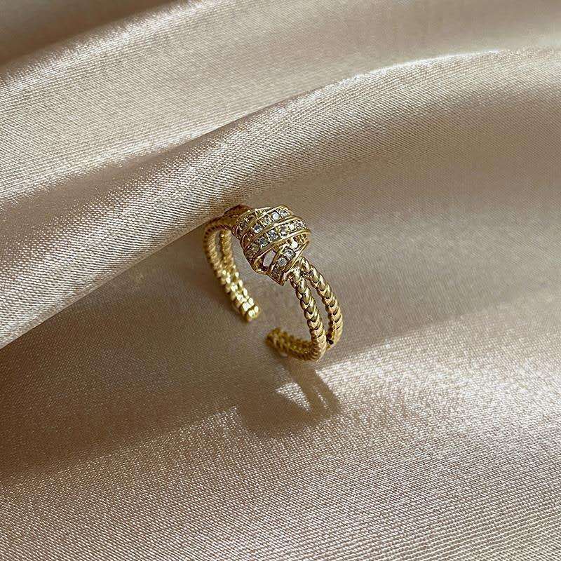 Gold ring with gemstones on a beige satin background