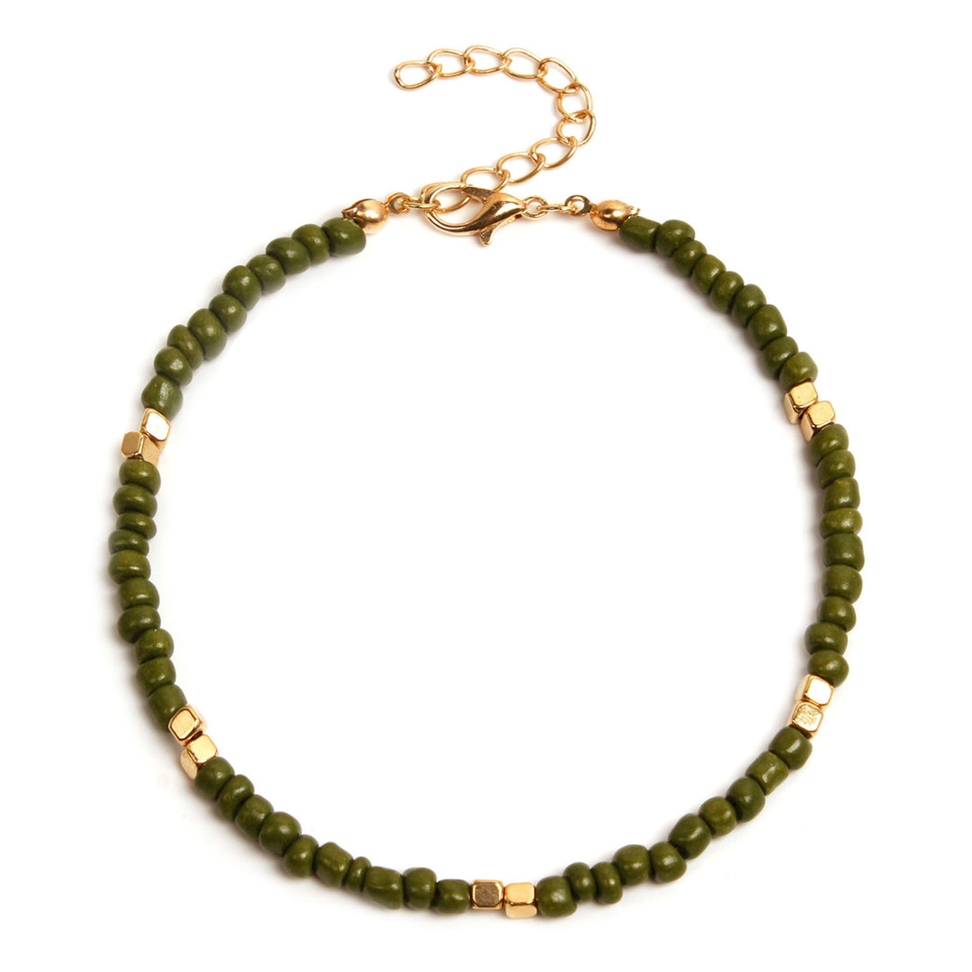 Green beaded anklet  with gold accents on a white background