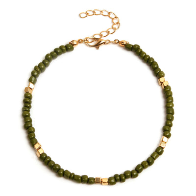 Green beaded anklet  with gold accents on a white background