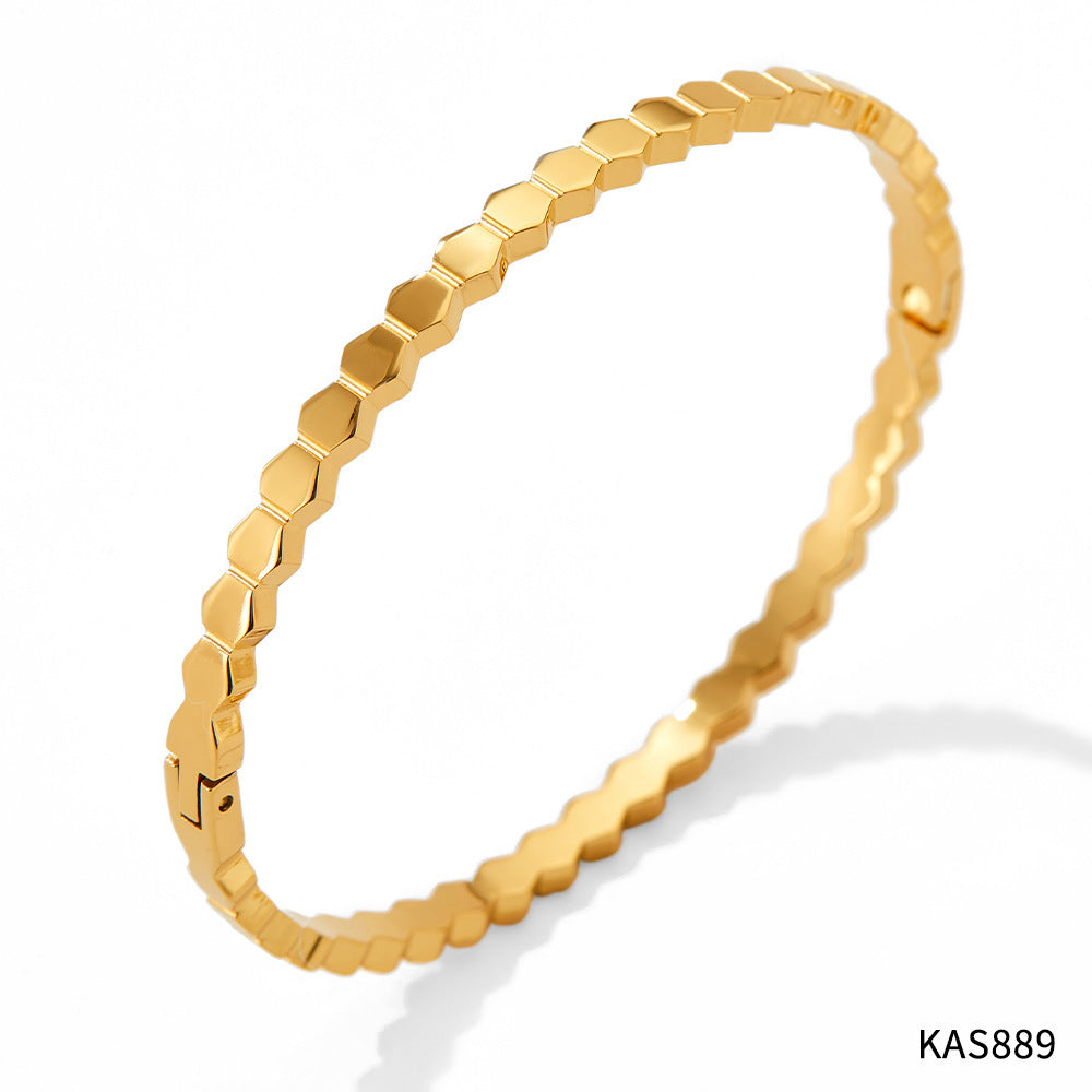 Gold bracelet with hexagonal pattern on a white background
