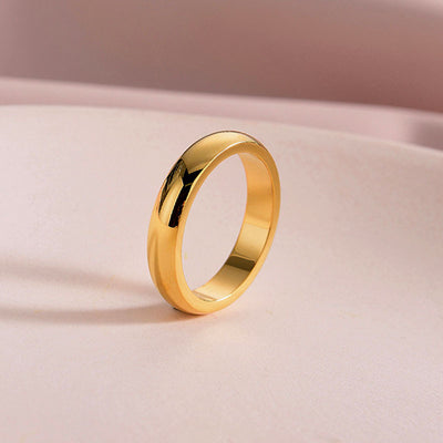 Gold ring on a light pink background