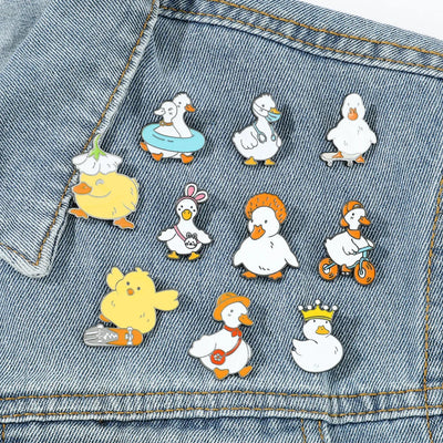 Set of cartoon duck pins on a denim background