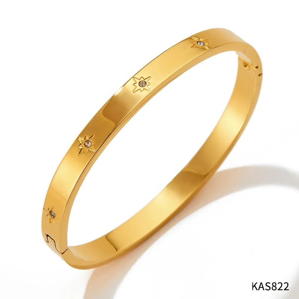 Gold bracelet with star designs on a white background