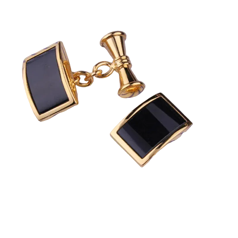 Gold cufflinks with black stones on a striped fabric background