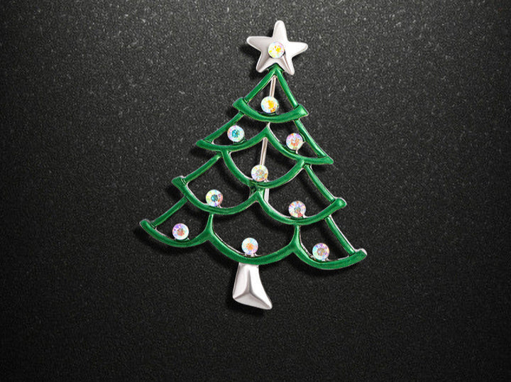 Green Christmas tree-shaped brooch with star on a black background