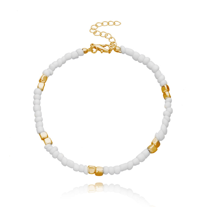 anklet  with white beads and gold accents on a white background
