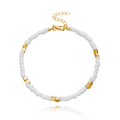 anklet  with white beads and gold accents on a white background