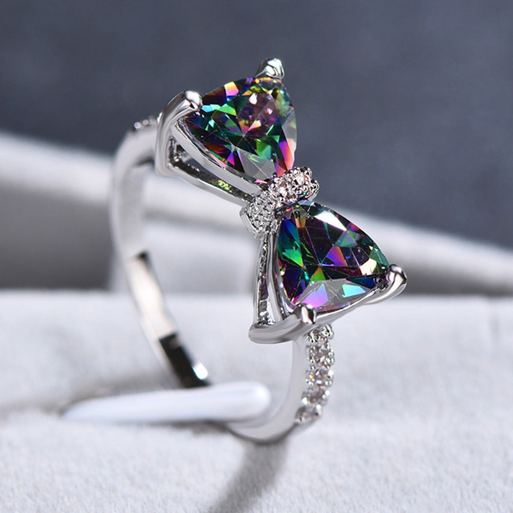 Multicolored gemstone ring with silver setting on a white surface