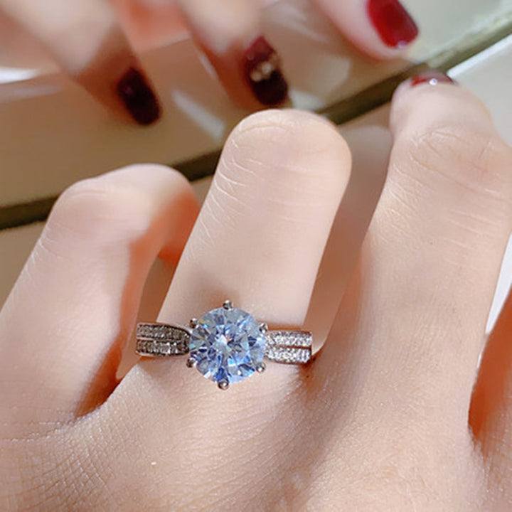 Close-up of a hand wearing a diamond ring with a blurred background