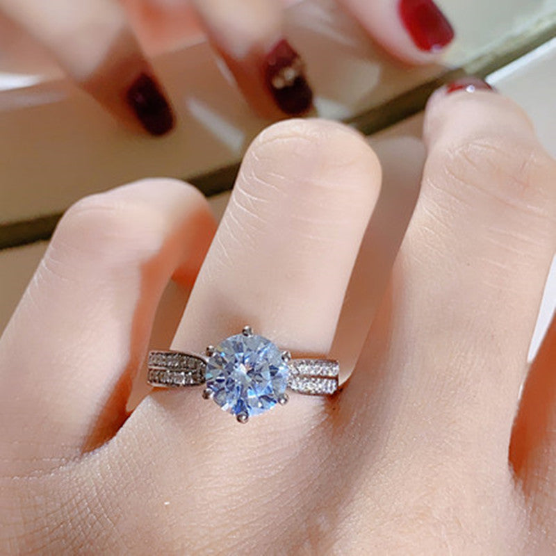Close-up of a hand wearing a diamond ring with a blurred background