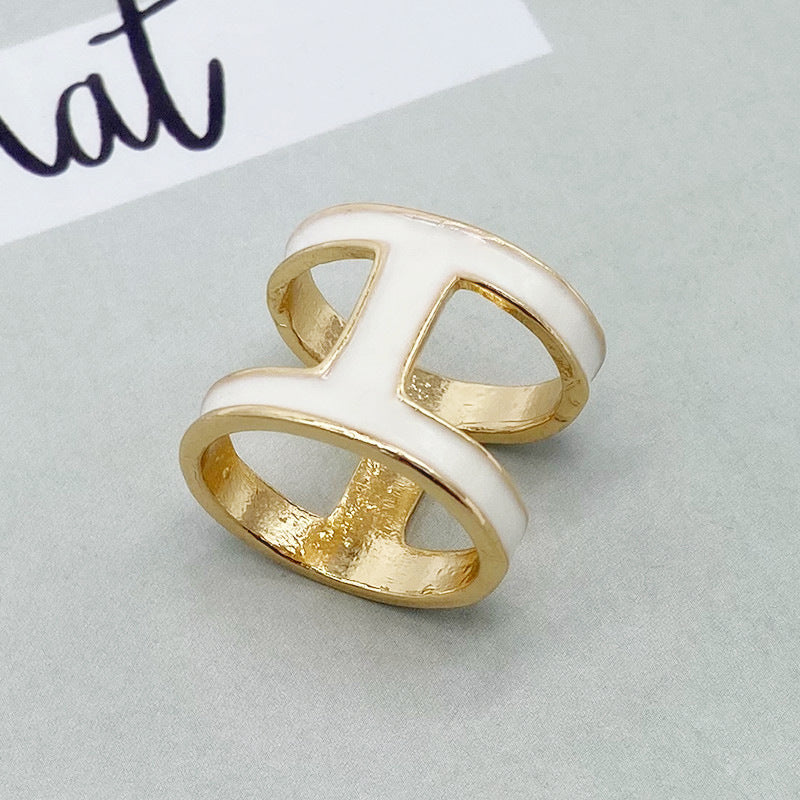 Gold and white ring on a light gray background